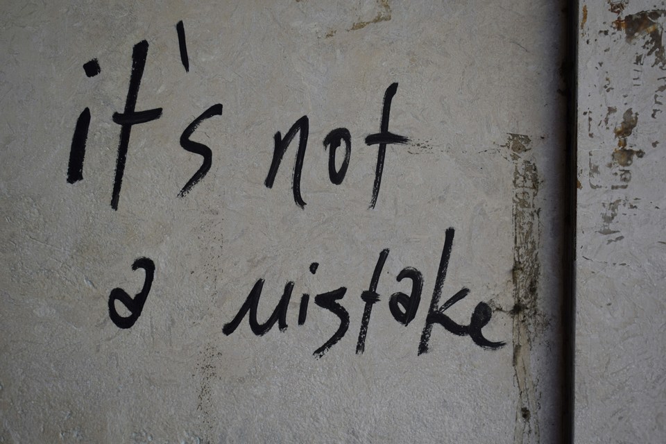 Street art graffiti reading "it's not a mistake" β reflecting how market mispricings are a feature, not a bug