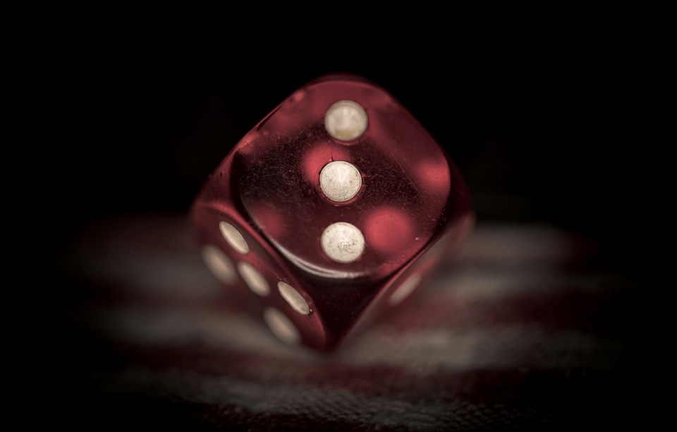 Close-up of a red translucent dice on a dark background β the dice roll thought experiment